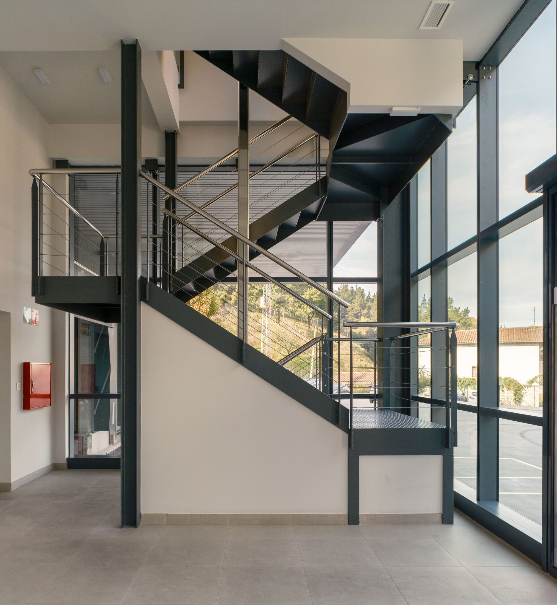 Escalera metálica junto al muro cortina en la nave de Fribasa